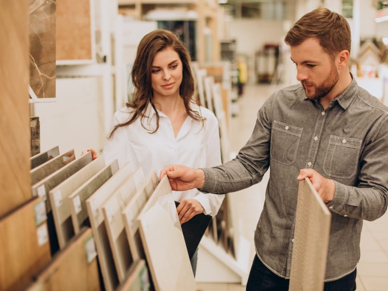 Young couple choosing tiles at building market